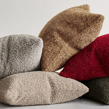 plush pillow cover in various colors stacked together, showcasing soft and cozy textures for home decor.